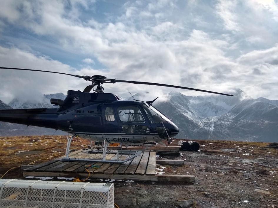 A black A-Star helicopter on a temporary landing pad in the mountains